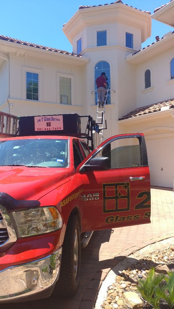 Bailey Glass Services truck on site with installer working on second-story windows