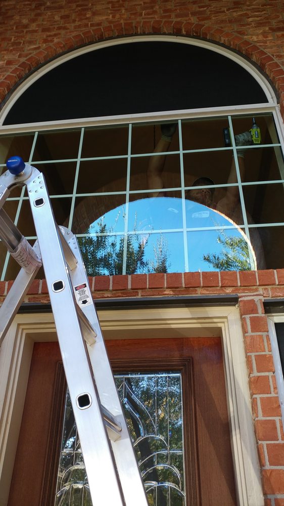 Arch-top window with grids above a wood entry door